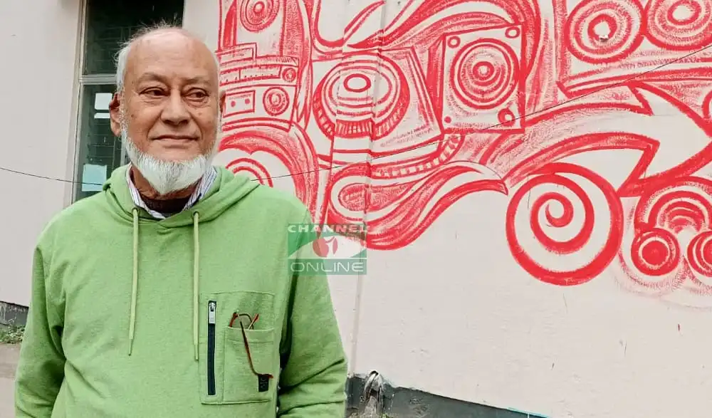 বয়স্ক ব্যক্তি একটি আর্ট ওয়াল পেইন্টের পাশে দাঁড়িয়ে আছেন, পেইন্টটি লাল রঙের আধুনিক শিল্পের ছবি. Channel i News - চ্যানেল আই নিউজ