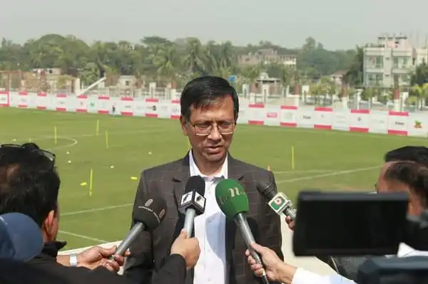 Bangladeshi official speaks to media at sports field during press conference. Channel i News - চ্যানেল আই নিউজ