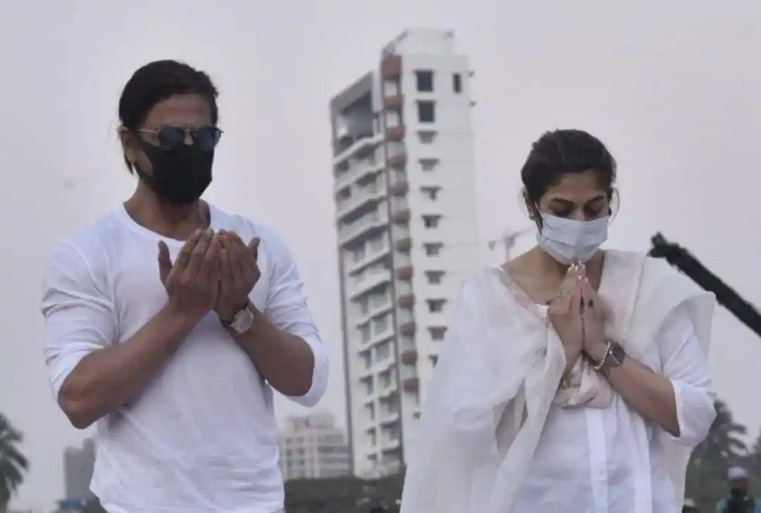 দুই ব্যক্তি প্রার্থনা ও শ্রদ্ধা নিবেদন করছেন, masks পরা. Channel i News - চ্যানেল আই নিউজ