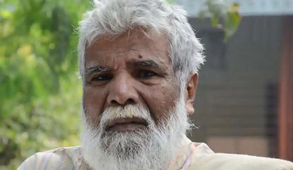 বৃদ্ধ পুরুষের মুখের ছবি, গা darken, হালকা পেছনে সবুজ গাছপালা. Channel i News - চ্যানেল আই নিউজ