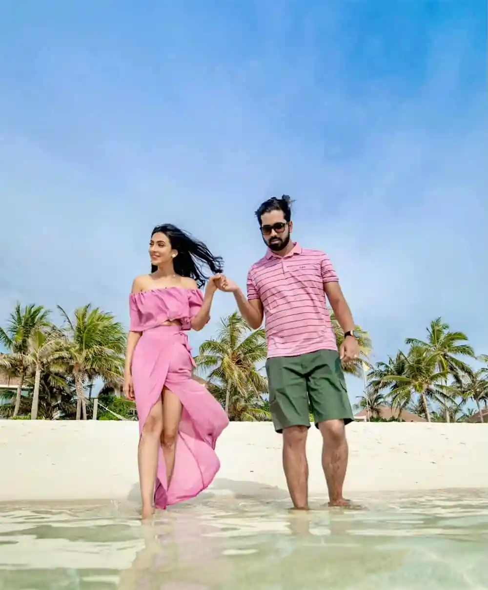 দম্পতি মালদ্বীপের সৈকতে হাঁটছে, সুন্দর আকাশ ও পাম গাছের পেছনে. Channel i News - চ্যানেল আই নিউজ