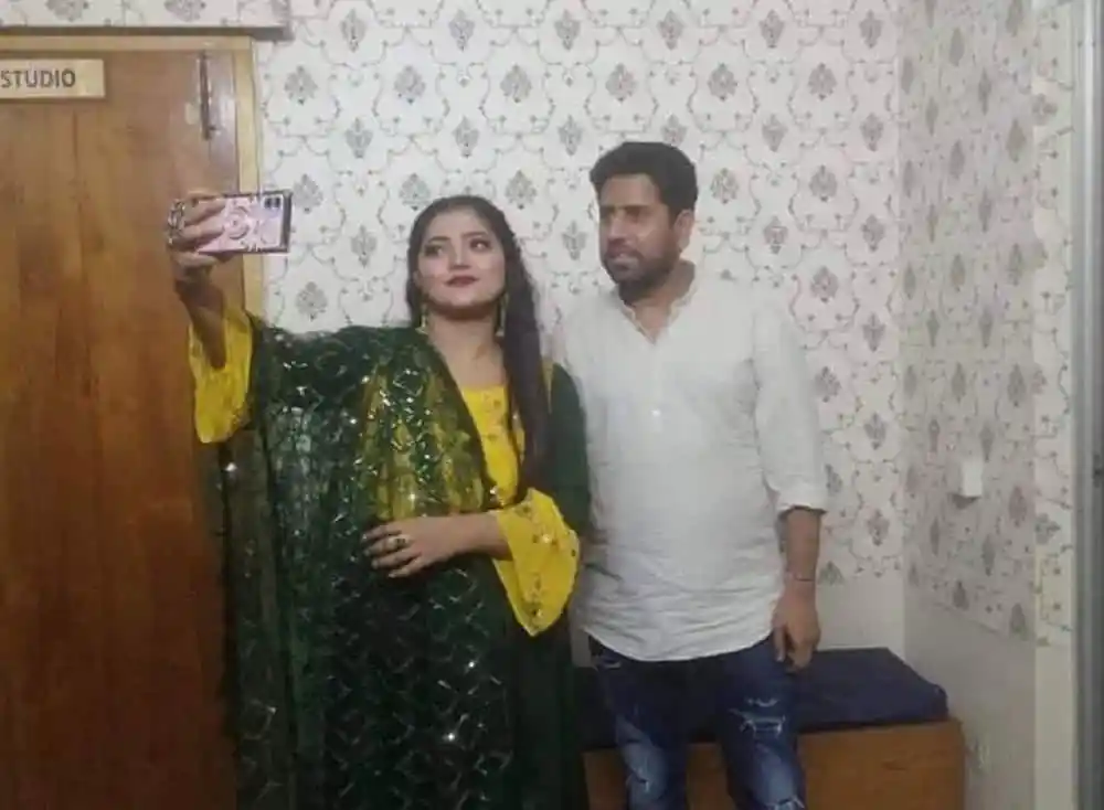 দুজন ব্যক্তি সেলফি তুলছেন, একজন মহিলার পোশাক সুন্দর।. Channel i News - চ্যানেল আই নিউজ