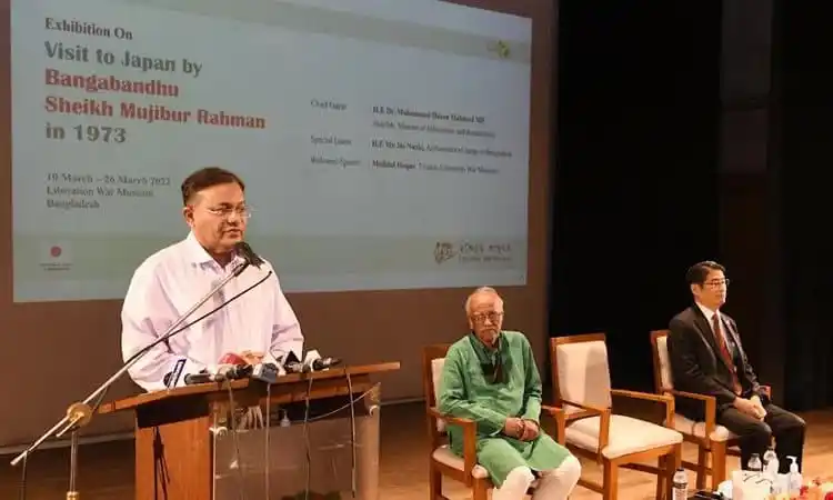 বাংলাদেশের একজন বক্তা ভাষণ দিচ্ছেন, অনুষ্ঠানে উপস্থিত অন্যরা বসে আছেন. Channel i News - চ্যানেল আই নিউজ