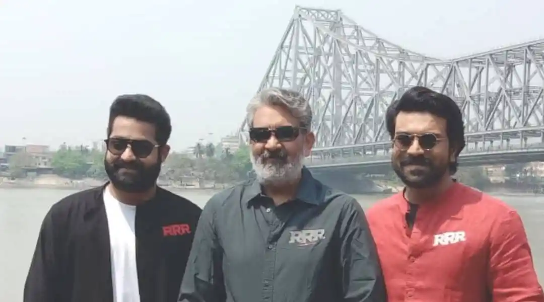 তিনজন ব্যক্তি নদীর পাশে দাঁড়িয়ে, সবাই সানগ্লাস পরা, হাসিমুখে. Channel i News - চ্যানেল আই নিউজ
