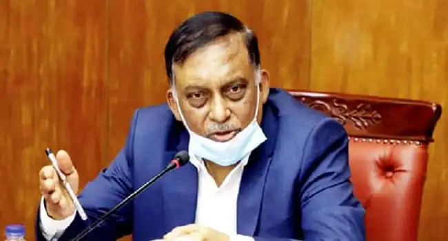 স্বরাষ্ট্রমন্ত্রী তদন্তের বিষয়ে কথা বলছেন, মুখে মাস্ক পরা. Channel i News - চ্যানেল আই নিউজ