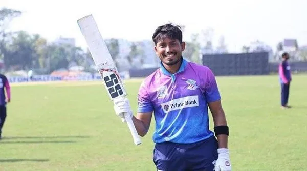 ক্রিকেট খেলোয়াড় মাঠে হাসিমুখে ব্যাট হাতে দাঁড়িয়ে. Channel i News - চ্যানেল আই নিউজ