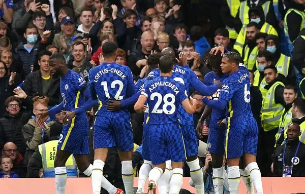 Chelsea players celebrate during a Champions League match with fans in the background. Channel i News - চ্যানেল আই নিউজ