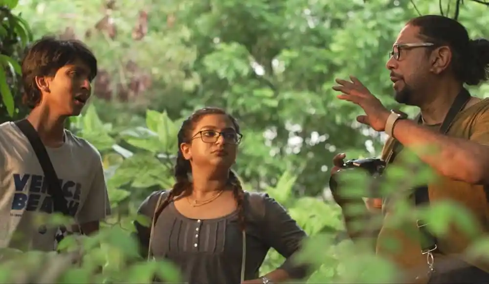 প্রাকৃতিক পরিবেশে তিনজন ব্যক্তি আলোচনা করছে, সবুজ গাছপালা ও পাতা চারপাশে. Channel i News - চ্যানেল আই নিউজ