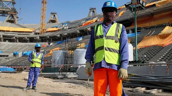 Construction workers wearing safety gear at a stadium site in Qatar. Channel i News - চ্যানেল আই নিউজ