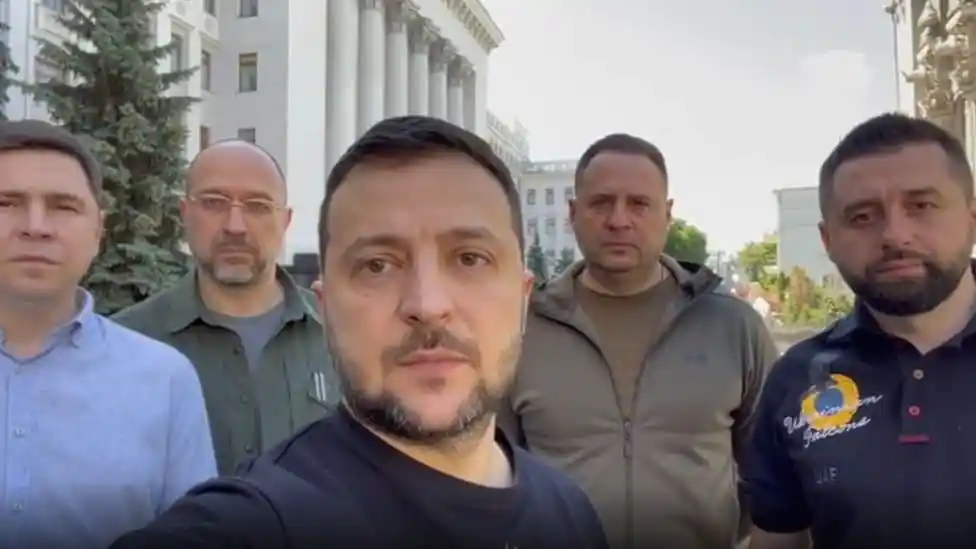Five men standing outdoors in front of a government building. Channel i News - চ্যানেল আই নিউজ