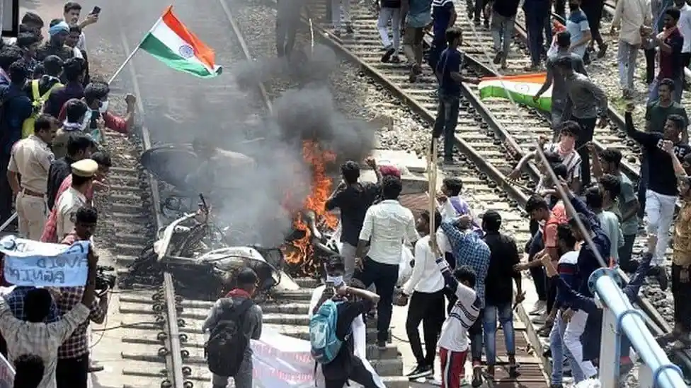 ভারতের বিক্ষোভে ট্রেনের ট্র্যাকের উপর আগুন ও প্রতিবাদকারীরা. Channel i News - চ্যানেল আই নিউজ