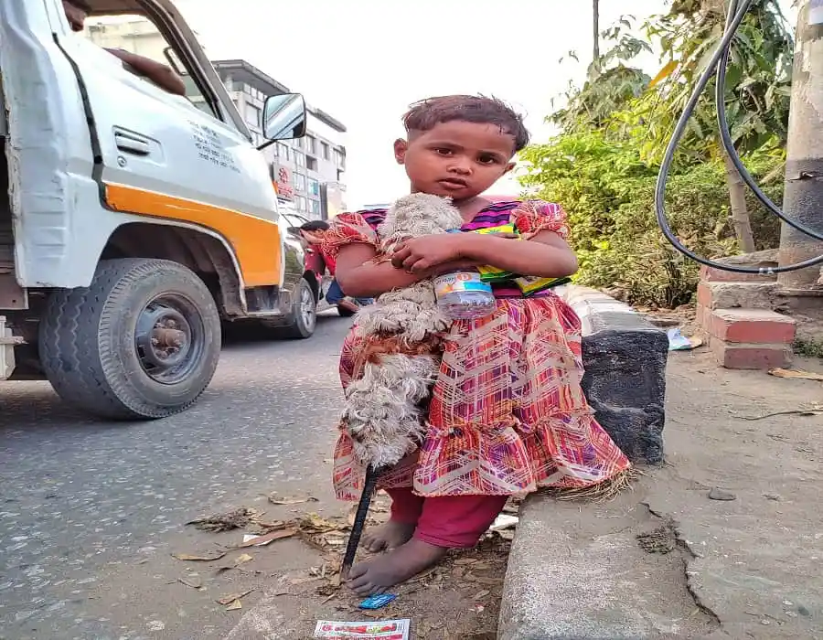 Pathshishu girl holding a dog on the street in Bangladesh. Channel i News - চ্যানেল আই নিউজ