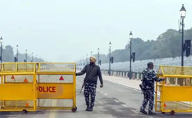 Bangladeshi police officers block a street with yellow barricades. Channel i News - চ্যানেল আই নিউজ