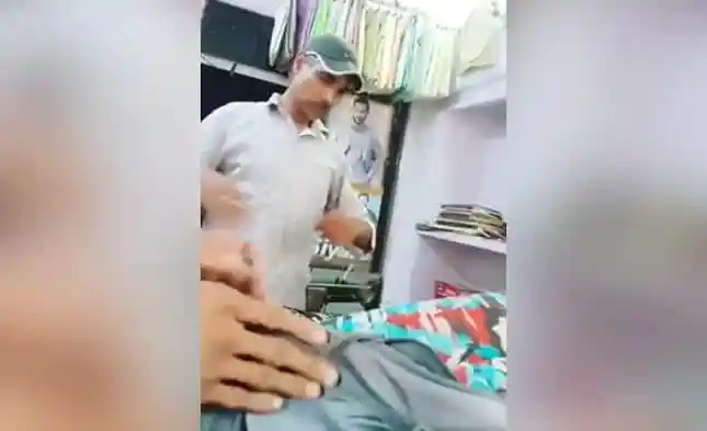 ব্যক্তি একটি দোকানে পোশাক দেখছেন বা পরীক্ষা করছেন. Channel i News - চ্যানেল আই নিউজ