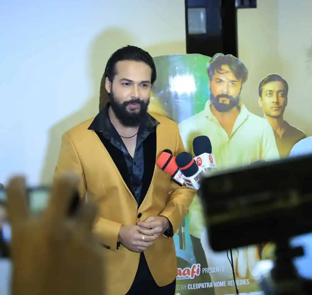 অভিনেতা সংবাদ সম্মেলনে কথা বলছেন, পেছনে ছবি ও ক্যামেরা. Channel i News - চ্যানেল আই নিউজ