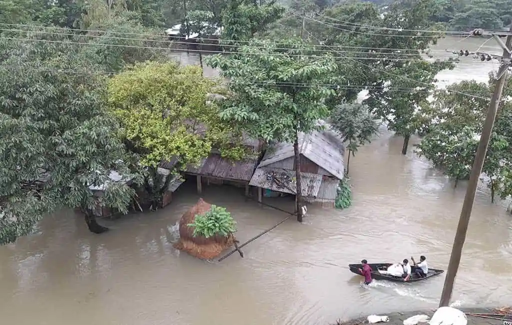 বন্যার পানিতে ডুবে গেছে বাড়িঘর ও রাস্তা, মানুষ নৌকায় চলাচল করছে. Channel i News - চ্যানেল আই নিউজ