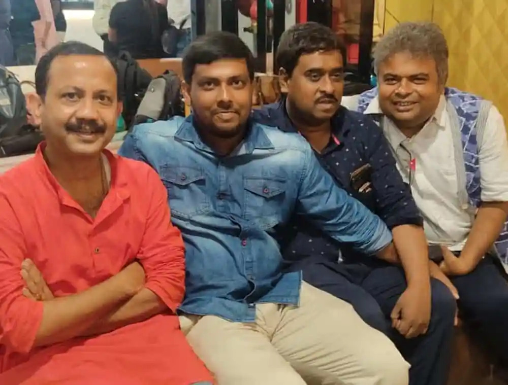 চারজন পুরুষ হাসিমুখে বসে আছেন, ক্যাফে বা রেস্তোরাঁর ভিতরে. Channel i News - চ্যানেল আই নিউজ