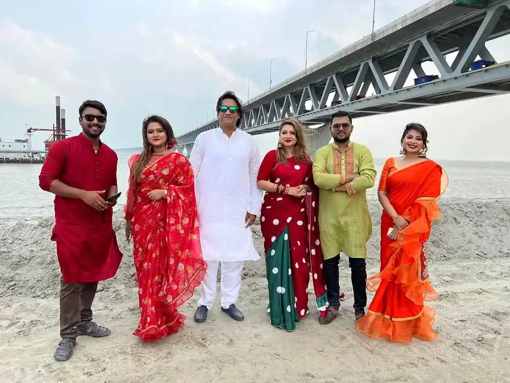 সন্ধ্যায় পদ্মা সেতুর পাশে ছয়জন ব্যক্তি ছবি তুলছেন. Channel i News - চ্যানেল আই নিউজ