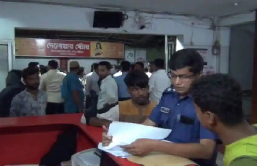 Bangladesh police officer reviewing documents at a busy office counter. Channel i News - চ্যানেল আই নিউজ