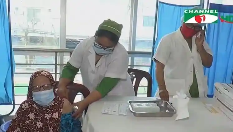 স্বাস্থ্যকর্মীরা করোনা টিকা দিচ্ছেন, রোগী বসে আছেন. Channel i News - চ্যানেল আই নিউজ