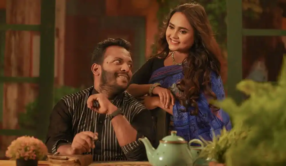 একজন পুরুষ ও একজন নারী হাসিমুখে বসে আছেন, প্রকৃতির মাঝে. Channel i News - চ্যানেল আই নিউজ