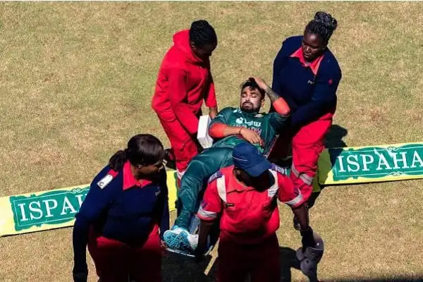 খেলোয়াড় আহত অবস্থায় চিকিৎসা নিচ্ছেন, মাঠে চারজন সহায়তা করছেন. Channel i News - চ্যানেল আই নিউজ