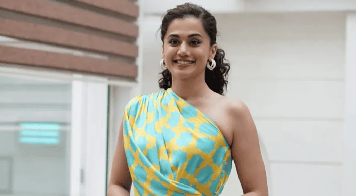 তাপসী হাসিমুখে দাঁড়িয়ে, আধুনিক পোশাক পরা ছবি।. Channel i News - চ্যানেল আই নিউজ