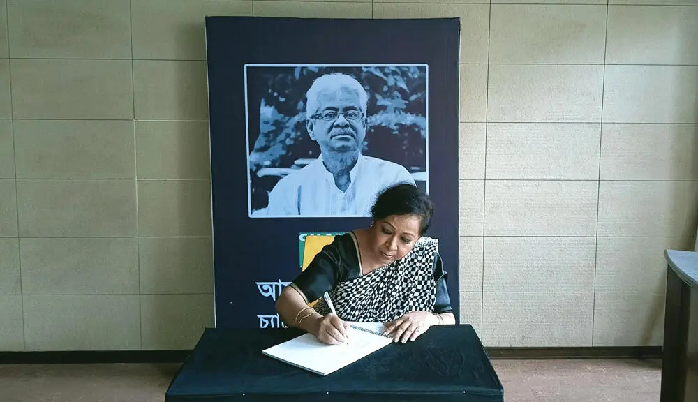গাজী মাজহারুল আনোয়ারের স্মরণে শোক বইয়ে স্বাক্ষর করছেন একজন নারী. Channel i News - চ্যানেল আই নিউজ