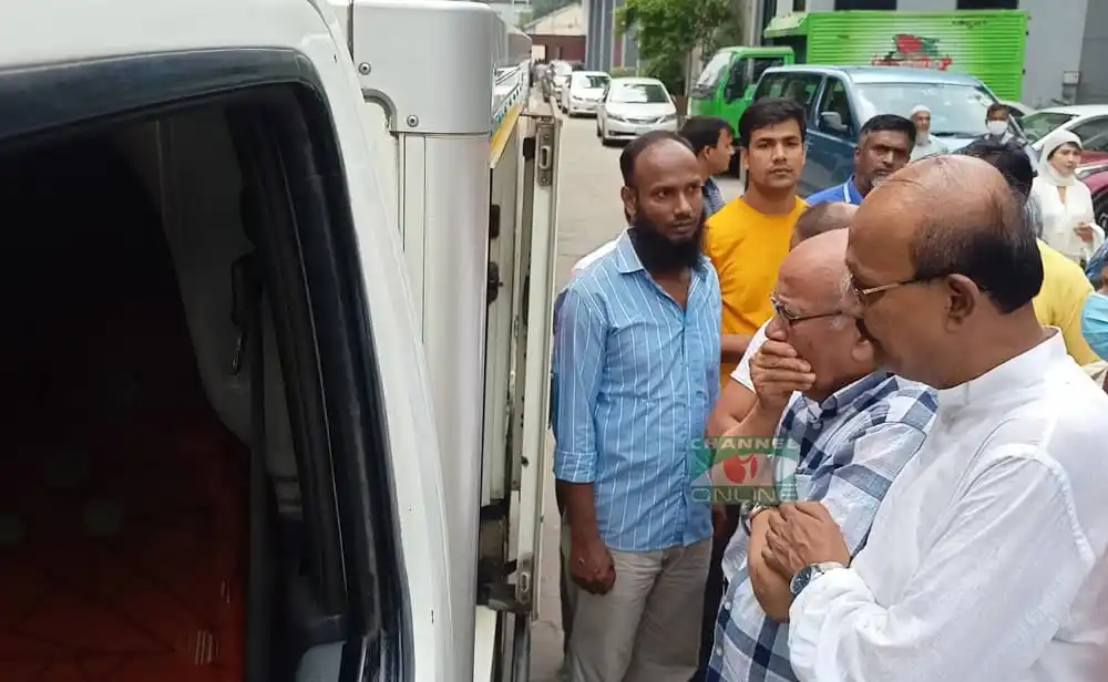 খুরশীদ আলমের সামনে লাশবাহী গাড়ির দৃশ্য, লোকজন উপস্থিত. Channel i News - চ্যানেল আই নিউজ