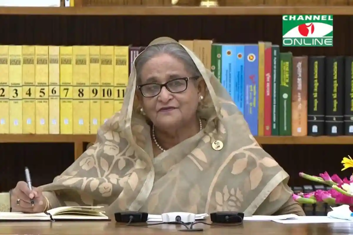 বাংলাদেশের একজন মহিলা নেতা বা কর্মকর্তা, বইয়ের সামনে বসে আলোচনা করছেন. Channel i News - চ্যানেল আই নিউজ