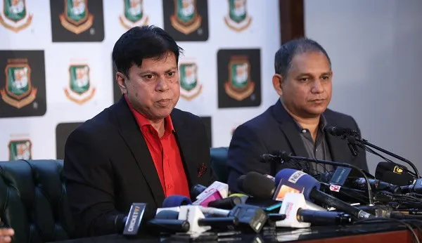 দুই ব্যক্তি সংবাদ সম্মেলনে বসে, microphones ও ক্যামেরার সামনে. Channel i News - চ্যানেল আই নিউজ