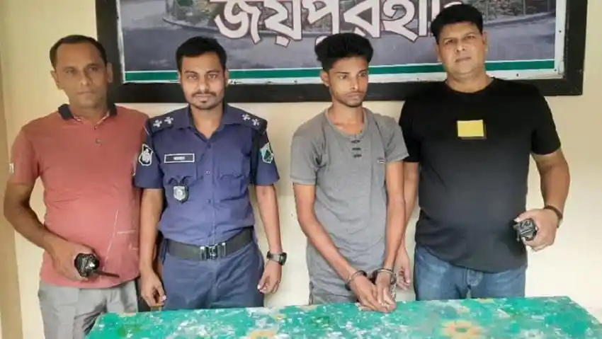 Four men, including a police officer, standing behind a table with a green cloth. Channel i News - চ্যানেল আই নিউজ