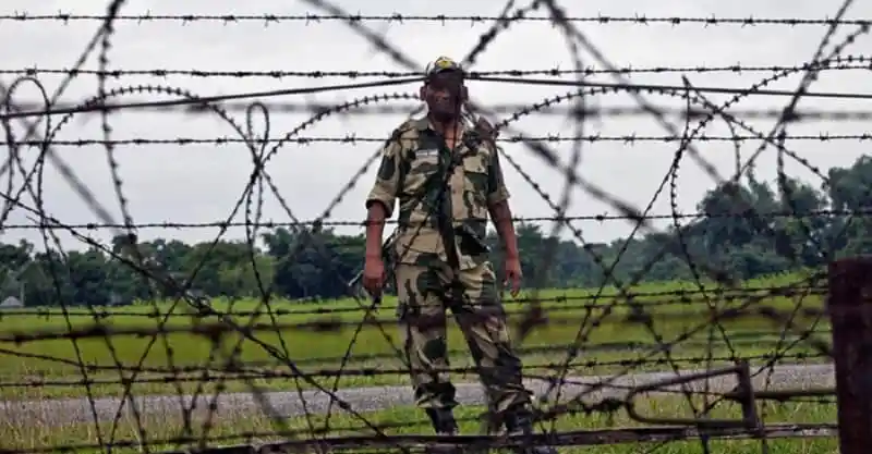 সেনা সদস্য সীমান্তে নজরদারি করছেন, বেড়া ও তারের পেছনে কৃষি জমি দেখা যাচ্ছে. Channel i News - চ্যানেল আই নিউজ