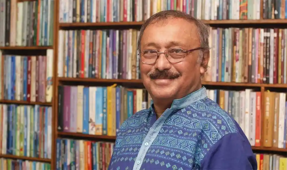 আলী ইমাম, শিশুসাহিত্যিক, বইয়ের সামনে হাসিমুখে ছবি. Channel i News - চ্যানেল আই নিউজ