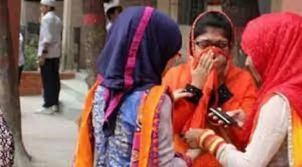 Bangladeshi women wearing traditional attire and face masks in a street scene. Channel i News - চ্যানেল আই নিউজ