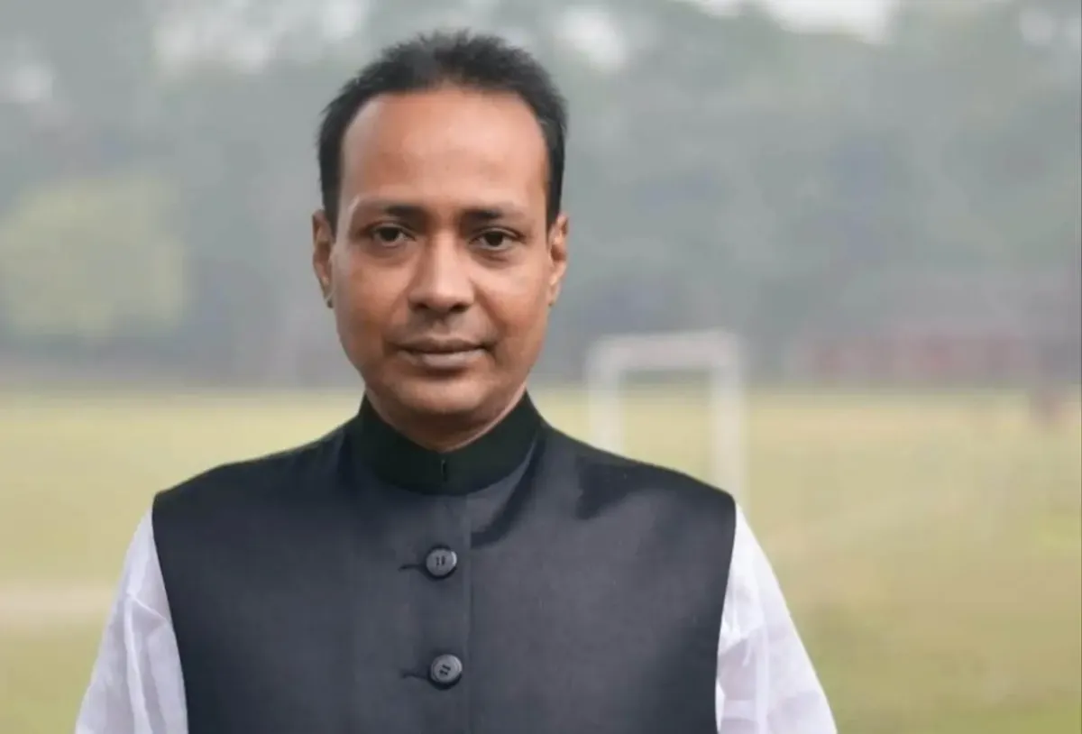 বাংলাদেশের একজন পুরুষ সাংবাদিক বা নেতা, পটভূমিতে খেলার মাঠ।. Channel i News - চ্যানেল আই নিউজ