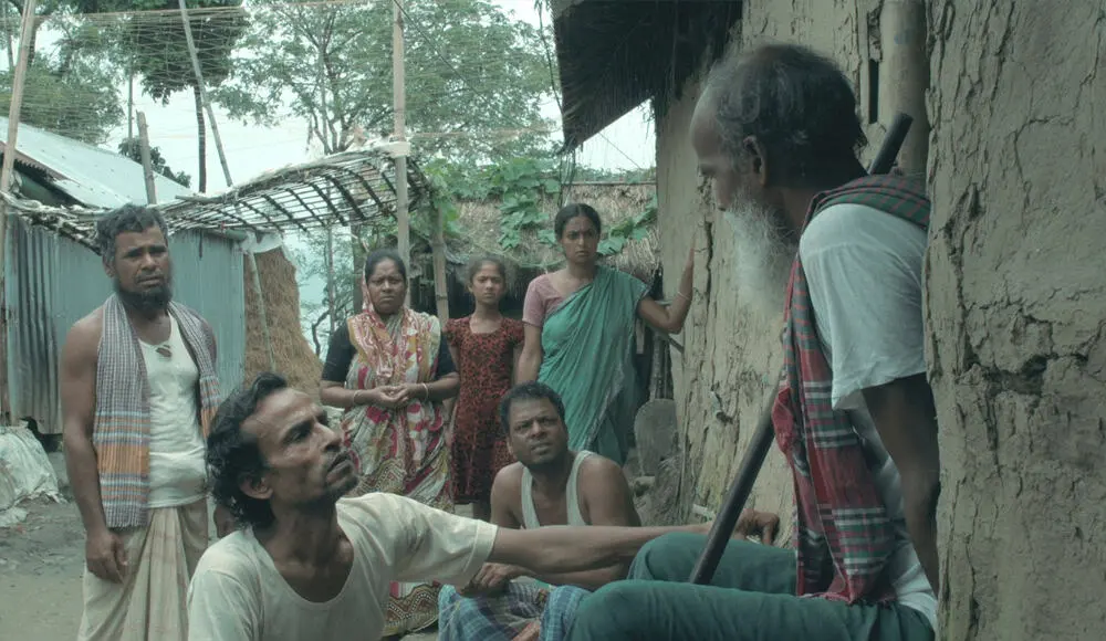 একজন বৃদ্ধ ব্যক্তি অন্য একজনের সাথে কথা বলছেন, অন্যরা দেখছেন. Channel i News - চ্যানেল আই নিউজ