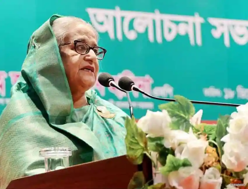 প্রধানমন্ত্রী ভাষণ দিচ্ছেন, পত্রিকা ও ফুলের সামনে. Channel i News - চ্যানেল আই নিউজ