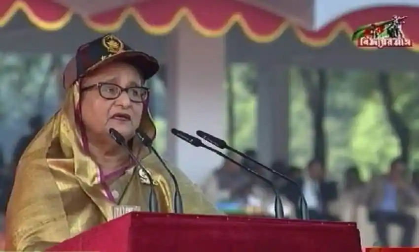 প্রধানমন্ত্রী ভাষণ দিচ্ছেন, পত্রিকা ও মাইক্রোফোনের সামনে. Channel i News - চ্যানেল আই নিউজ