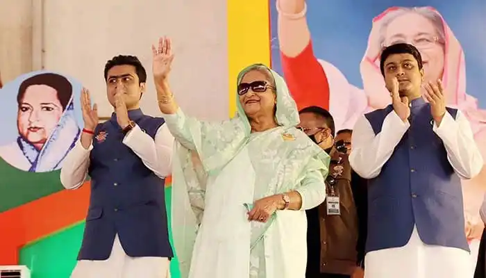 প্রধানমন্ত্রী জনসভায় ভাষণ দিচ্ছেন, নেতাকর্মীরা পাশে দাঁড়িয়ে. Channel i News - চ্যানেল আই নিউজ
