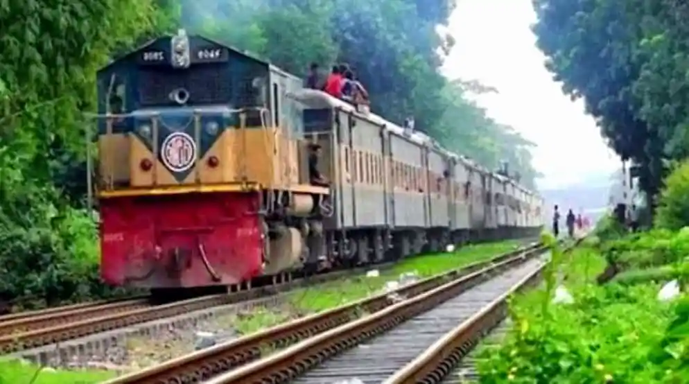 দ্রুত গতির ট্রেন রেললাইনের উপর দিয়ে যাচ্ছে, চারপাশে সবুজ গাছপালা।. Channel i News - চ্যানেল আই নিউজ