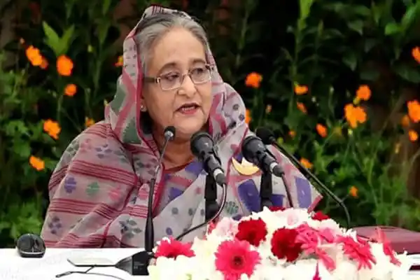 প্রধানমন্ত্রী ভাষণ দিচ্ছেন, ফুলের বাগানে, গাছের পেছনে. Channel i News - চ্যানেল আই নিউজ