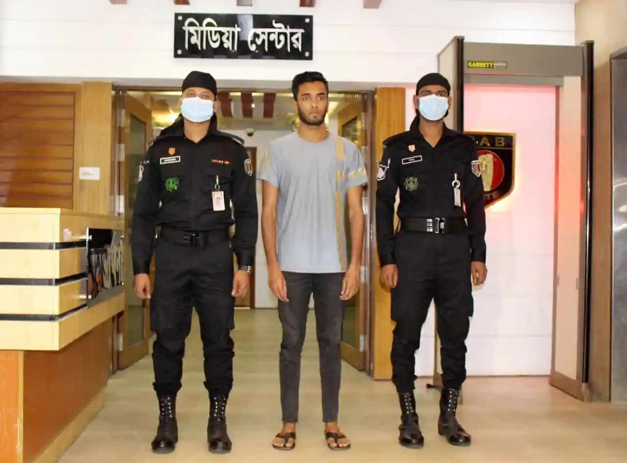 অভিযুক্ত যুবককে দুই পুলিশ সদস্যের সঙ্গেই দেখা যাচ্ছে।. Channel i News - চ্যানেল আই নিউজ