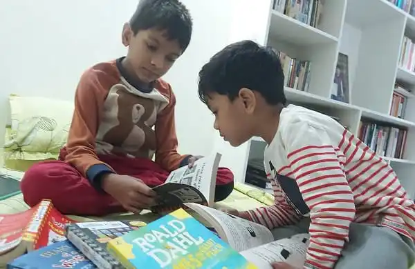 দুই শিশু বই পড়ছে, বইয়ের পৃষ্ঠা উল্টাচ্ছে।. Channel i News - চ্যানেল আই নিউজ