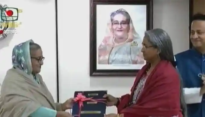 প্রধানমন্ত্রীর হাতে ফলাফলের কপি হস্তান্তর করছেন একজন নারী. Channel i News - চ্যানেল আই নিউজ
