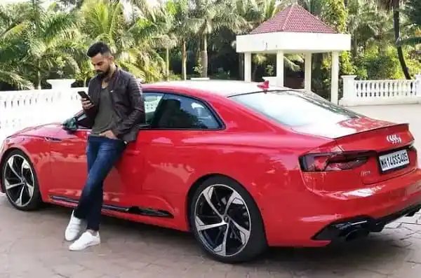 কোহলি তার নতুন লাল অডি কোরেটা গাড়ির পাশে দাঁড়িয়ে থাকছেন।. Channel i News - চ্যানেল আই নিউজ