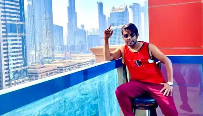 শহরের আকাশে উঁচু ভবন ও আকাশের দৃশ্যের পাশে বসে যুবক. Channel i News - চ্যানেল আই নিউজ