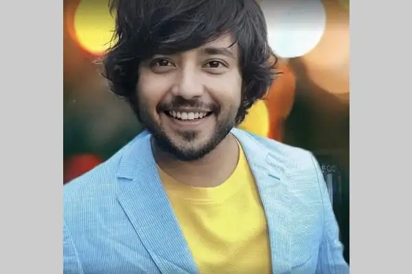 আনন্দিত যুবক হাসিমুখে, ব্যাকগ্রাউন্ডে আলো ঝলমল।. Channel i News - চ্যানেল আই নিউজ
