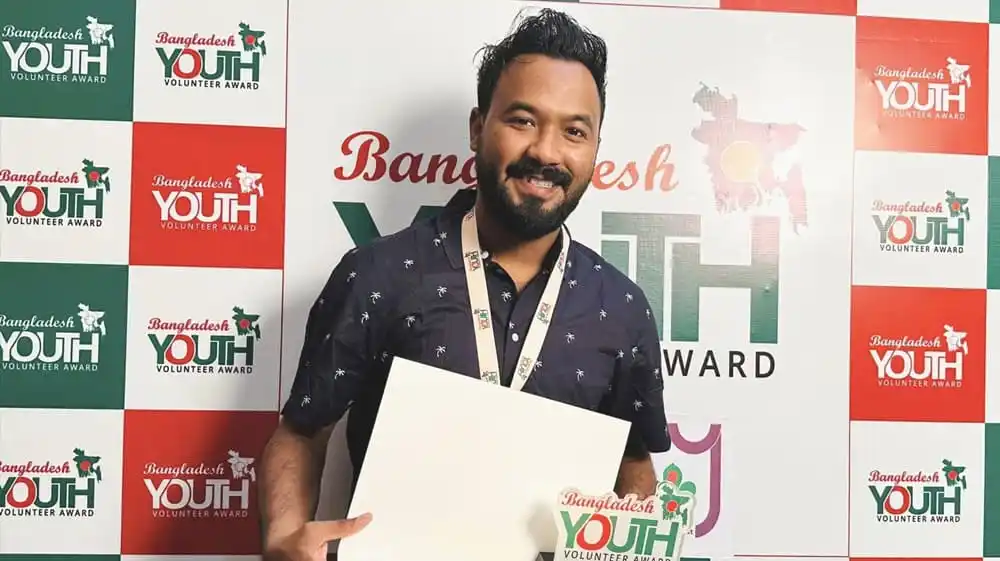 পলাশের ‘ডাকবাক্স’ প্রকল্পের জন্য সম্মাননা গ্রহণ করছেন একজন ব্যক্তি. Channel i News - চ্যানেল আই নিউজ