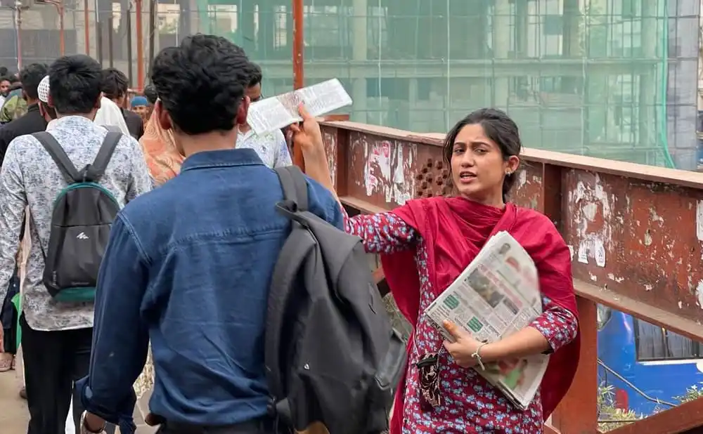 রাস্তায় খবরের কাগজ বিক্রি করছেন সাফা, পথচারীদের সঙ্গে কথা বলছেন. Channel i News - চ্যানেল আই নিউজ